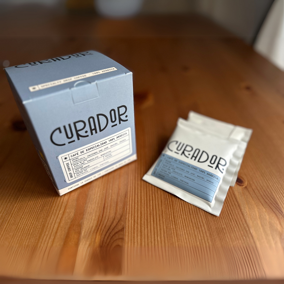 Drip bags de café de especialidad Curador sobre mesa de madera.