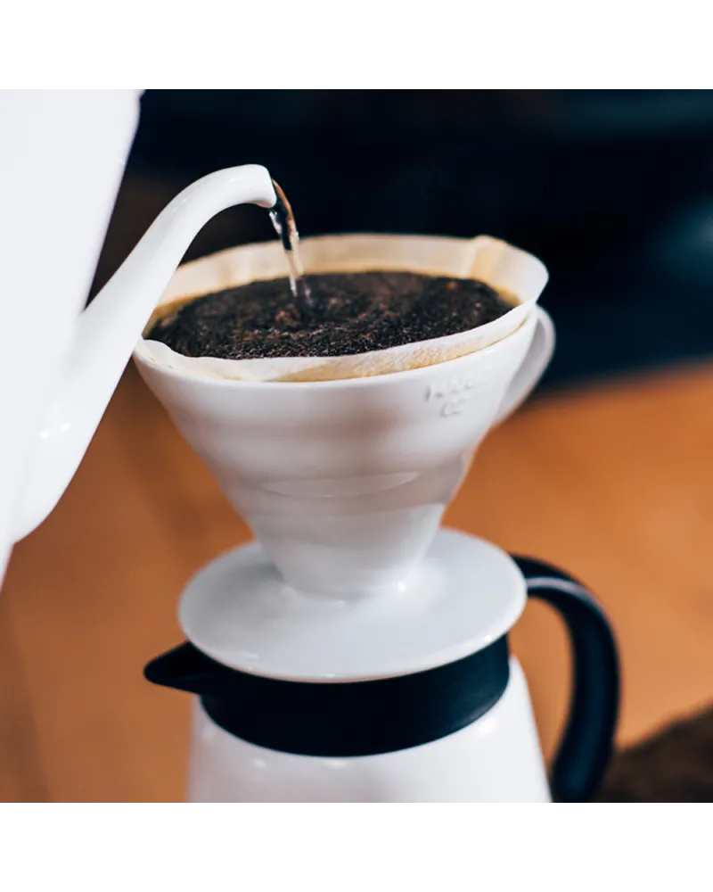 Hario V60 cono de cerámica blanca para preparar café manual con filtro y diseño en espiral.