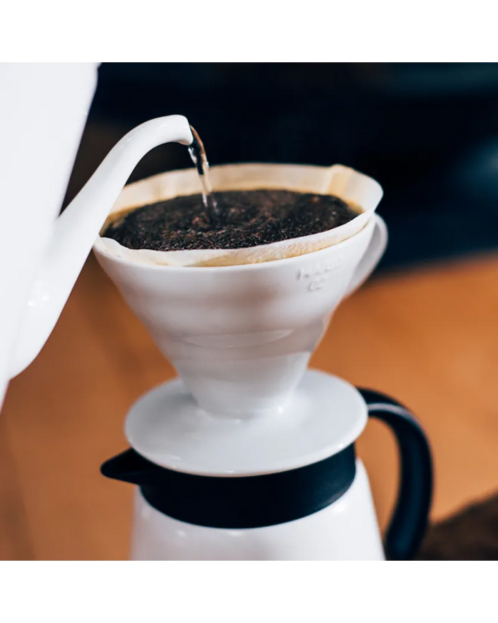 Hario V60 cono de cerámica blanca para preparar café manual con filtro y diseño en espiral.