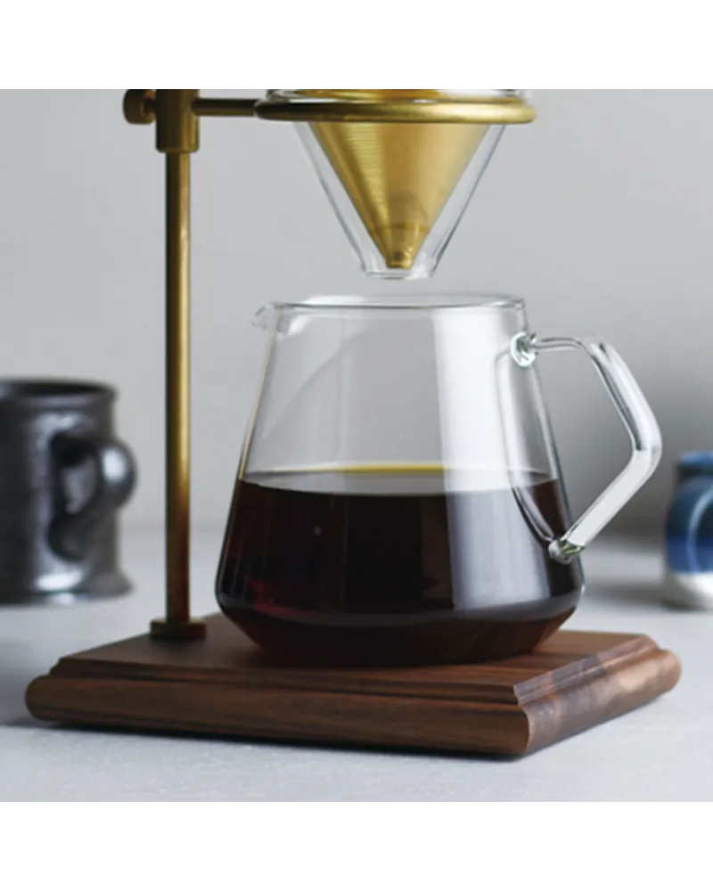 Jarra de café Kinto de vidrio con capacidad de 600 ml sobre base de madera, diseñada para un servicio artesanal elegante y funcional.